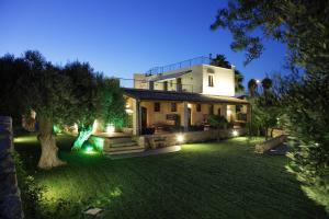 a large house with lights in a yard at night at Casal Sikelio in Cassibile