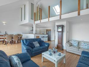 uma sala de estar com sofás azuis e uma mesa em Pass the Keys Celyn Y Mor Stunning Rhosneigr Family Beach House em Rhosneigr