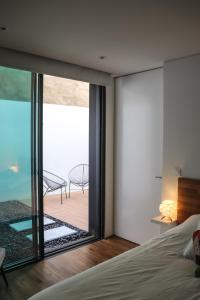 a bedroom with a bed and a view of a patio at Aljube Residences I - Apt novo, com terraço, centro PDL in Ponta Delgada