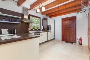 a kitchen with a wooden door and white cabinets at Wypoczynek w domu nad morzem in Łukęcin