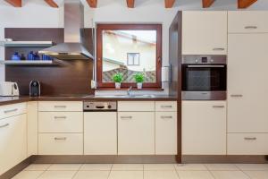 a kitchen with white cabinets and a window at Wypoczynek w domu nad morzem in Łukęcin