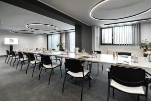 uma grande sala de conferências com uma mesa longa e cadeiras em Elegans Hotel Brdo em Kranj