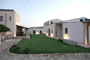 a courtyard of a house with a green lawn at Casal Sikelio in Cassibile