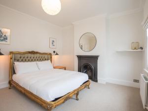 1 dormitorio con 1 cama con chimenea y espejo en Pass the Keys Cheerful Roomy 6 Sleeper in Central Windsor with Garden, en Windsor