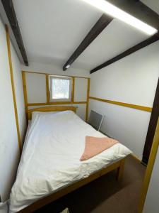 Bett in einem kleinen Zimmer mit Fenster in der Unterkunft Hotel Mlyn in Nikolayev