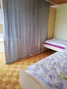 a bedroom with two beds and a curtain at Haus Petra in Neumarkt in Steiermark