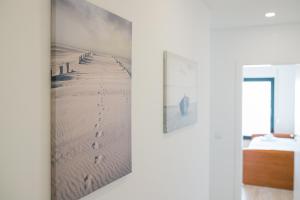 mural mural de una playa con huellas en la arena en SwordFish Sea View Apartment, en Peniche
