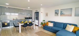 Una sala de estar con un sofá azul y una cocina. en SwordFish Sea View Apartment, en Peniche