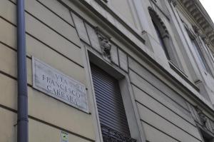 una señal en el lateral de un edificio con ventana en Carrara 24, en Roma