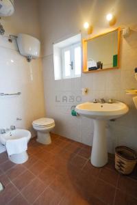 La salle de bains est pourvue d'un lavabo, de toilettes et d'un miroir. dans l'établissement Residenza Crivo, à Parghelia