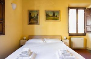 1 dormitorio con 1 cama con toallas en Cozy classic Italian house near Santa Croce, on the Lungarno, en Florencia