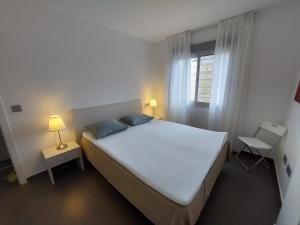 sypialnia z białym łóżkiem i oknem w obiekcie La Manga Beach Club - A w mieście La Manga del Mar Menor
