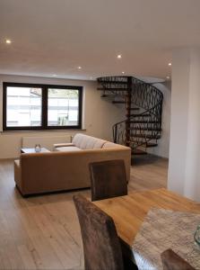 uma sala de estar com um sofá e uma escada em espiral em Haus Herrloch em Hermeskeil