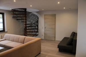 - un salon avec un canapé et un escalier en colimaçon dans l'établissement Haus Herrloch, à Hermeskeil