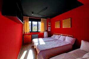Dormitorio rojo con cama y sofá en Loft Gijón, en Gijón