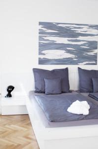 KozÃ¡rovice的住宿－Vilas & Wellness Resort Orlík，一张带蓝色枕头的白色床和绘画