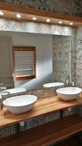 łazienka z 2 białymi umywalkami na drewnianym blacie w obiekcie Mas la Mouillere w mieście Camélas
