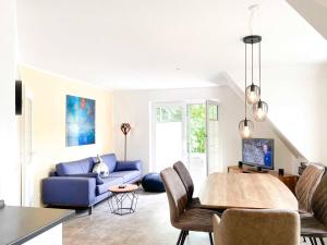 sala de estar con sofá azul y mesa en Kormoran 19, en Zingst