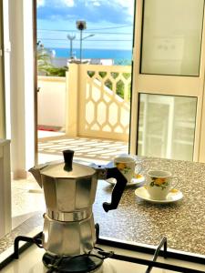 eine Kaffeemaschine auf einer Theke mit zwei Tassen in der Unterkunft Le macchie - Vacanza nel verde in Torre Vado