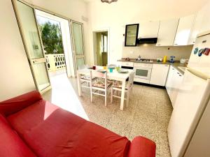 Il comprend un salon avec un canapé rouge et une cuisine. dans l'établissement Le macchie - Vacanza nel verde, à Torre Vado