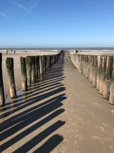 a long pier on the beach with people in the background at B&B Zee van Tijd Domburg in Domburg