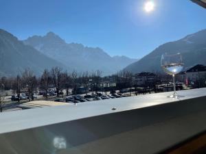 a glass of wine sitting on a ledge with a view at CitySuite Lienz in Lienz