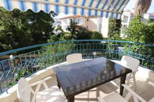 een tafel en witte stoelen op een balkon bij Nella Maisonette Hanioti in Hanioti