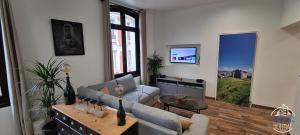 a living room with a couch and a table at Quintessence By JPS Holiday, Splendide appartement au coeur de Dieppe in Dieppe