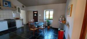 a kitchen with a table and chairs in a room at Quinta Cunte - Casa Sobreiro in São Luis