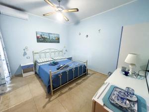 - une chambre bleue avec un lit et un ventilateur de plafond dans l'établissement CASA VACANZA MERY, à Tricase