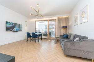 a living room with a couch and a table at Pomorskie Apartamenty Bernadowska Gold in Gdynia