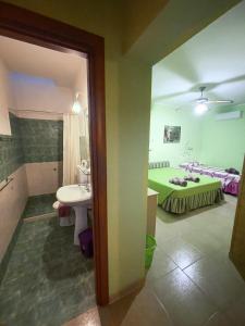 La salle de bains est pourvue d'un lavabo et d'un lit dans la chambre. dans l'établissement CASA VACANZA MERY, à Tricase