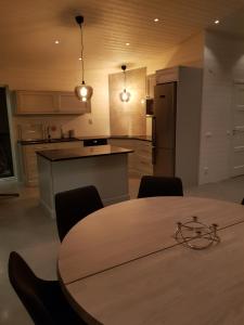 a kitchen with a wooden table with chairs and a kitchen with a refrigerator at Stuga (Cottage) ålaryd in Skillingaryd +7 photos