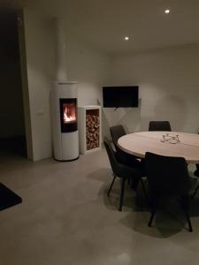 a living room with a table and a fireplace at Stuga (Cottage) ålaryd in Skillingaryd