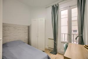 1 dormitorio con cama y ventana grande en Cómodo apartamento con 6 habitaciones en el centro, en Madrid