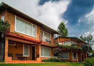 ein Haus mit Balkon an der Seite in der Unterkunft De Rock Jungle Living Resort in Coonoor