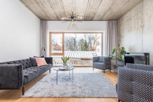 cohost I New Bastėja Life Apartments w-Garage Prkg & Self Check-in في فيلنيوس: غرفة معيشة مع أريكة وطاولة