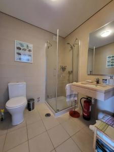 a bathroom with a shower and a toilet and a sink at Penthouse Roma in Fuzeta +11 photos