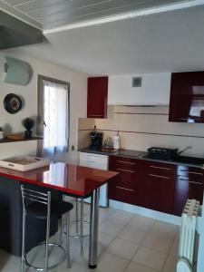 una cucina con isola rossa in una camera di Pavillon 4/6 pers. 30 m² Gruissan Les Ayguades a Gruissan Altre 11 foto