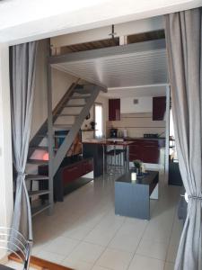 uma sala de estar com uma cama alta e uma cozinha em Pavillon 4/6 pers. 30 m² Gruissan Les Ayguades em Gruissan