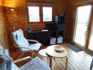 una sala de estar con sillas y una mesa en una cabaña en De Wingerd, en Bergakker