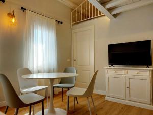 a dining room with a table and chairs and a tv at Canal Vena Suite House by ApartSuite in Chioggia