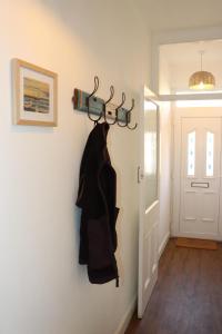 a coat hanging on a wall next to a door at Kindly Light Cottage in Amble