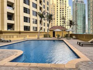 a large swimming pool in front of a building at HiGuests - Spacious Apt for 6 in JBR, minutes from the Beach in Dubai