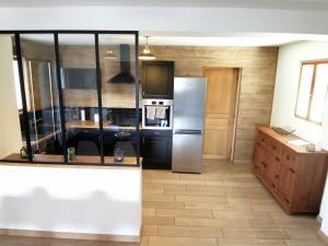 a kitchen with a stainless steel refrigerator in a room at Le chalet du Leman - Vue lac - Yvoire in Yvoire