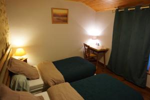 a small room with two beds and a desk at Chambre d'hôtes Kerioret Izella in Kerlaz