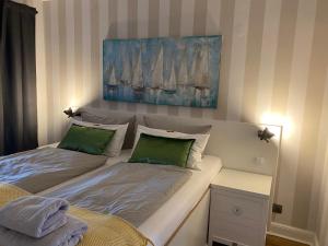 a bedroom with two beds and a painting on the wall at Relitto Boutique und Aparthotel Borkum in Borkum