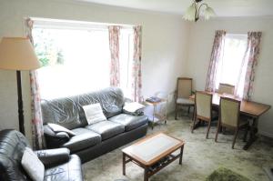 a living room with a couch and a table at Lamont Chalet Self catering holiday homes Creagmhor Glenelg IV408LA in Glenelg