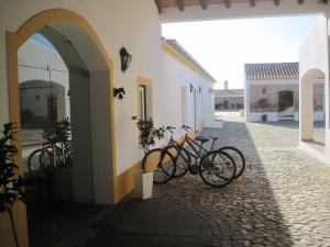 un groupe de vélos garés sur le côté d'un bâtiment dans l'établissement Outeiro Da Vila - Casas De Campo, à Vila Verde de Ficalho