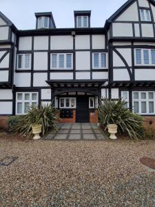 a black and white house with plants in front of it at Purdis Farm - Flat 4 in Bucklesham